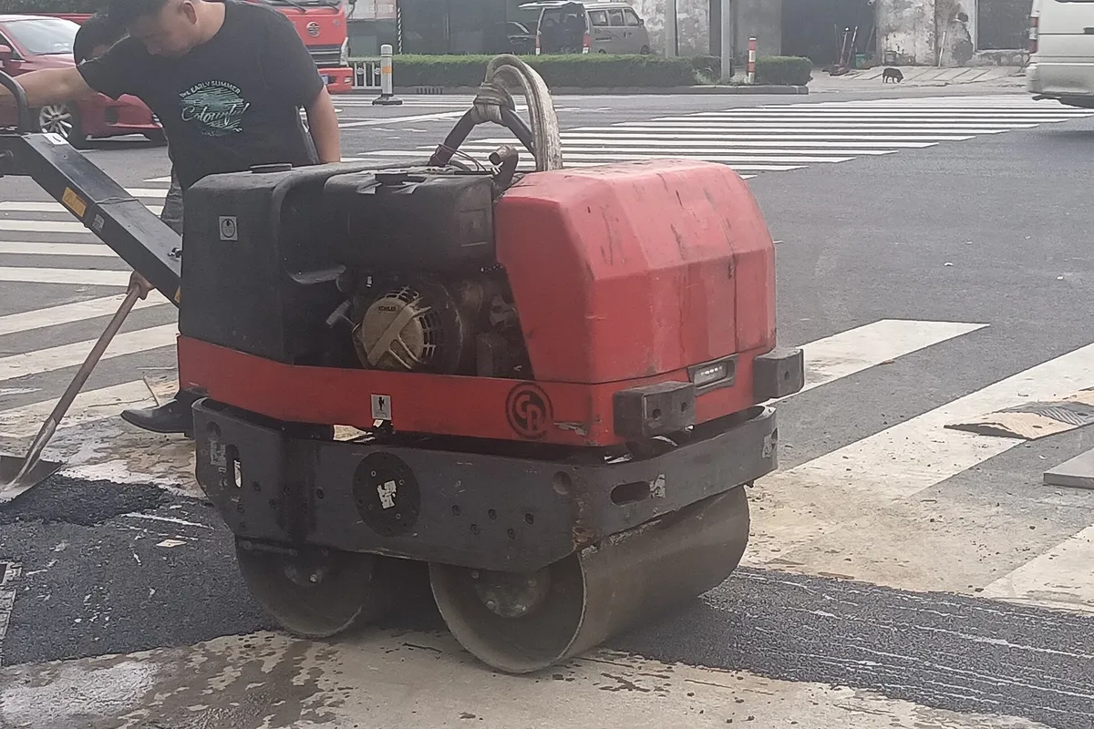 Máy lu rung dắt tay hai bánh thép trên mặt đường